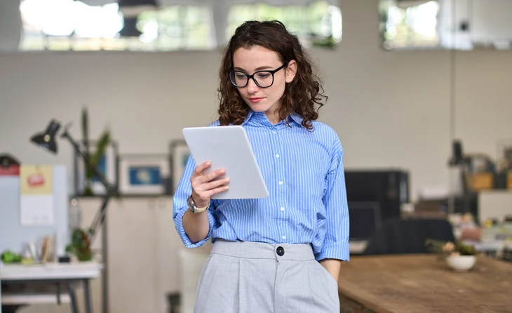 Groupe de travailleurs médicaux en blouse blanche assis autour du bureau pendant le cours de formation professionnelle, écoutant une conférencière expérimentée âgée